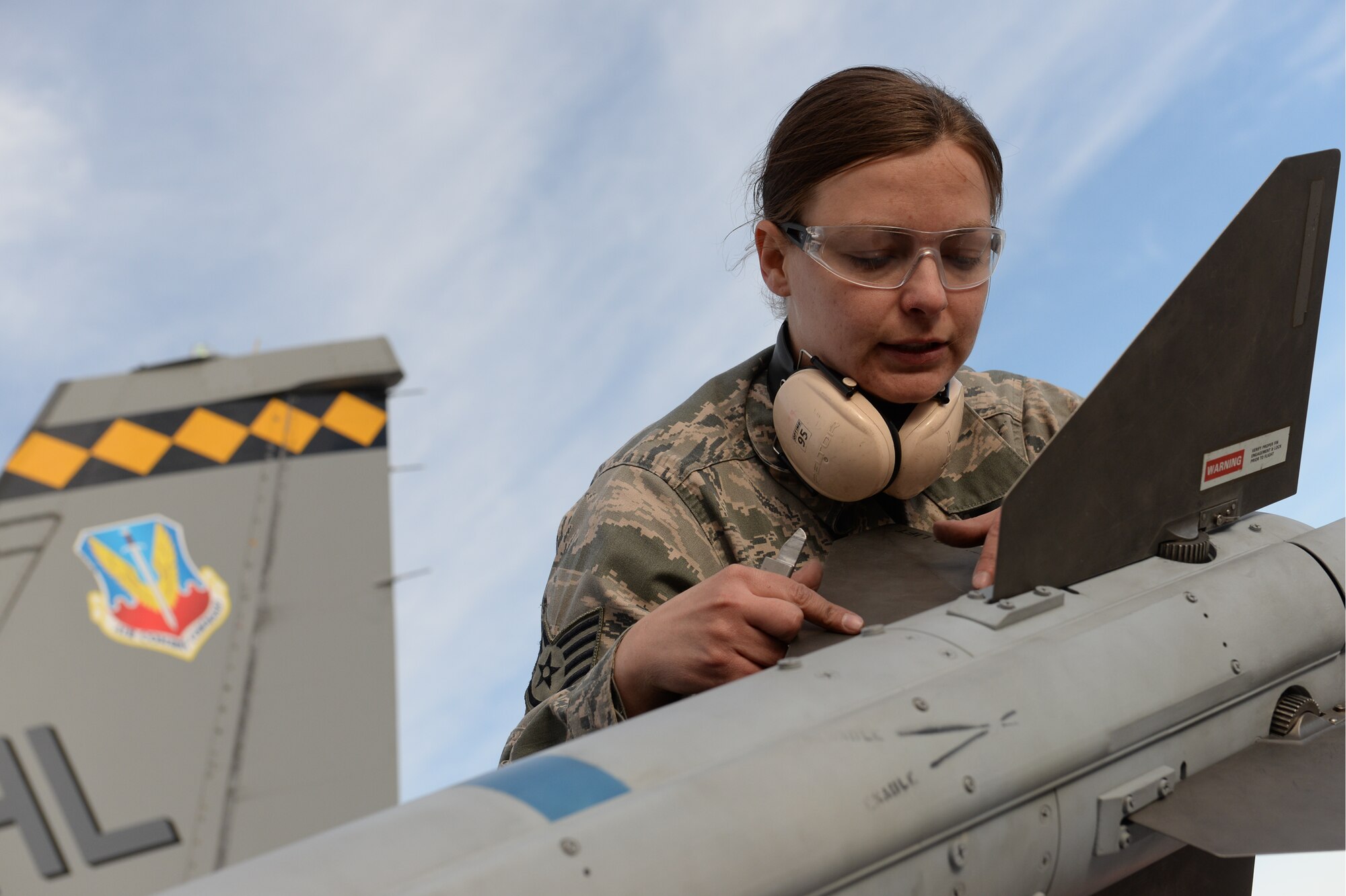 Staff Sgt. Sarah Limb, 466th Aircraft Maintenance Unit, installs fins on an AIM-120 missile April 8 at Hill Air Force Base, Utah. Limb installed the missile onto an F-16 aircraft during the 388th Fighter Wing’s quarterly weapons load competition, a competition that included a crew who loaded the first F-35 aircraft during such an event at the base. (U.S. Air Force photo by Paul Holcomb)