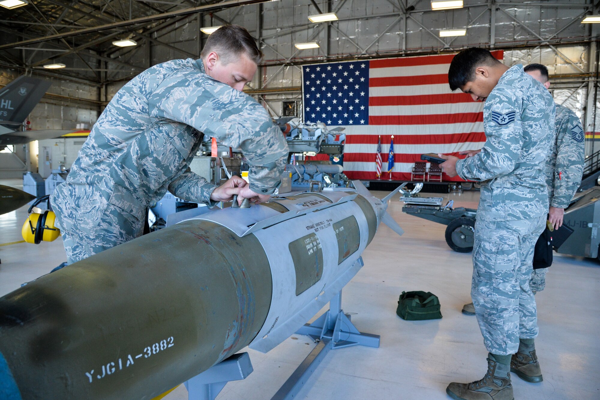 Senior Airman Hunter Swanson, foreground, and Staff Sgt. Lance Klain, both assigned to the 421st Aircraft Maintenance Unit, perform munitions preparation on a GBU-31 bomb April 8 at Hill Air Force Base, Utah. Swanson and Salazar, along with Senior Airman Zackary Salazar, competed against teams from the 4th Aircraft Maintenance Unit, 34th Aircraft Maintenance Unit, and 466th Aircraft Maintenance Unit in the 388th Fighter Wing’s quarterly weapons load competition. (U.S. Air Force photo by R. Nial Bradshaw)