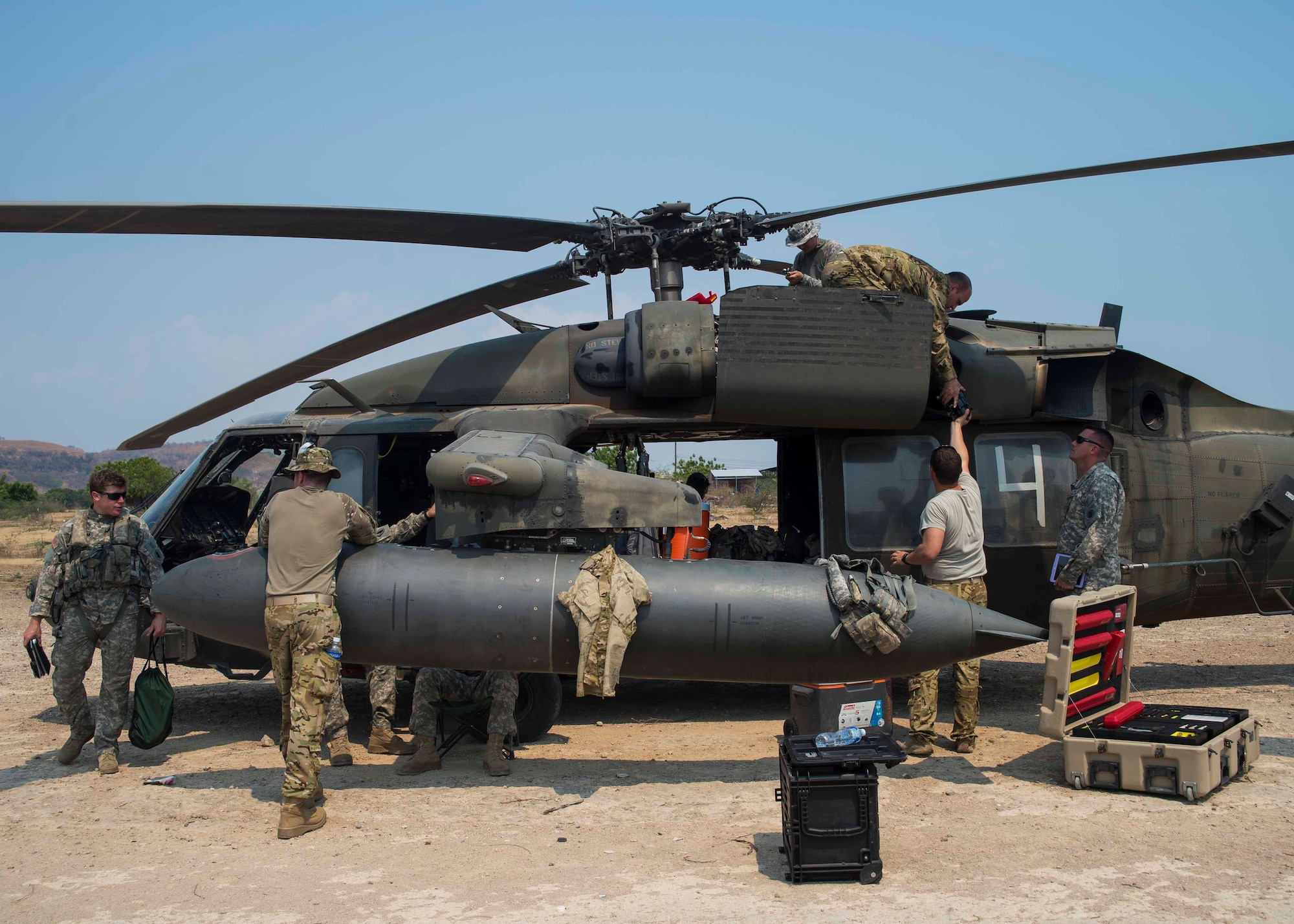 Members of the 1st Battalion, 228th Aviation Regiment, Joint Task Force Bravo at Soto Cano Air Base, Honduras, perform maintenance on a UH-60 Blackhawk helicopter at a forward area refueling point in Honduras, April 14, 2016. The FARP acted as a temporary rest and refuel point for aircraft and aircrew members, while conducting deck landing qualifications over the Caribbean Sea. (U.S. Air Force photo by Staff Sgt. Siuta B. Ika)