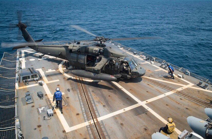 U.S. Navy sailors aboard the USS Lassen run toward a UH-60 Blackhawk assigned to the 1st Battalion, 228th Aviation Regiment, Joint Task Force Bravo at Soto Cano Air Base, Honduras, during the Blackhawk crew’s deck landing qualification off the coast of Honduras, April 14, 2016. The certification consists of flight deck landings and liftoff maneuvers with the crew of the Lassen assisting with signaling, placing wheel chocks, and securing the aircraft to the deck. (U.S. Air Force photo by Staff Sgt. Siuta B. Ika)