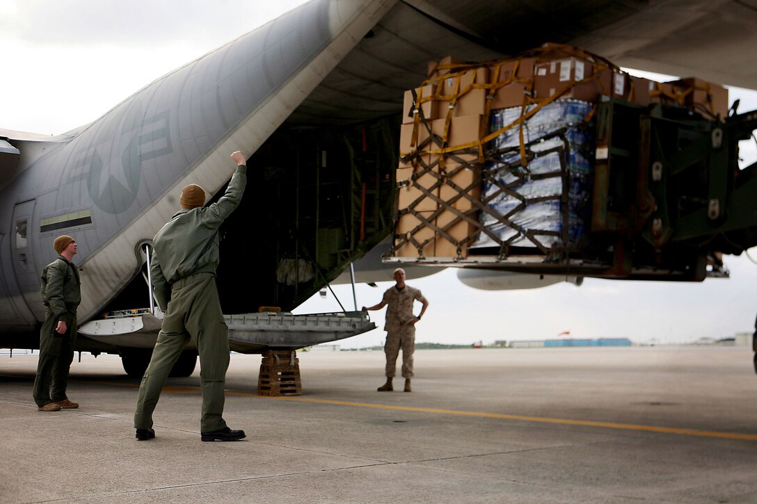 Marines load a pallet of bottled water and hazard protection gear into a KC-130J Super Hercules aircraft at U.S. Marine Corps Air Station Futenma in Japan, March 16, 2011. Following an April 16, 2016, earthquake near Kumamoto, Japan, U.S. forces in the country are preparing to support the Japanese government’s relief efforts. Marine Corps photo by Cpl. Dengrier M. Baez