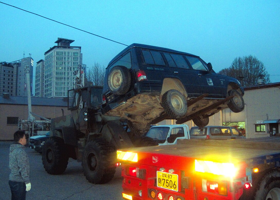 Morning came early at the Far East District motor pool, as tractor-trailers arrived just after 5 a.m. to haul obsolete vehicles to the Defense Reutilization Management Office (DRMO). The obsolete vehicles were loaded by forklift, tied down and departed the compound in about an hour.