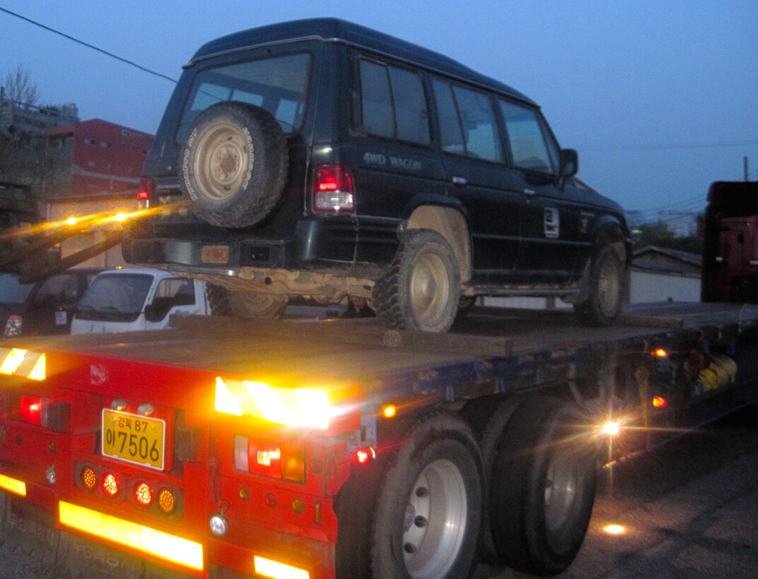 Morning came early at the Far East District motor pool, as tractor-trailers arrived just after 5 a.m. to haul obsolete vehicles to the Defense Reutilization Management Office (DRMO). The obsolete vehicles were loaded by forklift, tied down and departed the compound in about an hour.