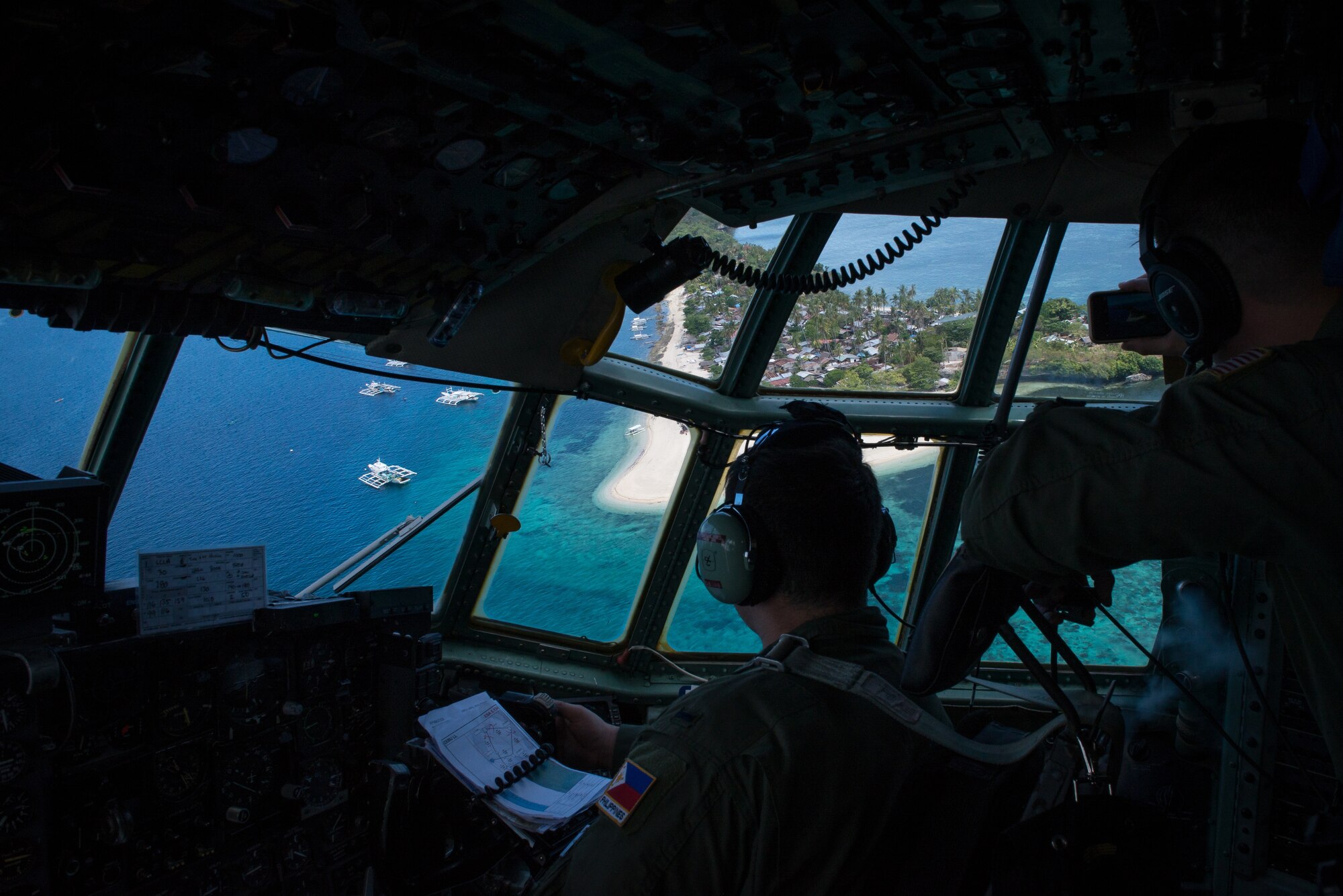 C-130 Hercules aircrew from the 36th Airlift Squadron look out the window during a flight over a small island in the Philippines as a part of Exercise Balikatan, April 14, 2016. Balikatan provides opportunities for U.S. and Philippine forces to learn from each other and train for potential real world crises, better preparing them to support the local population throughout the Indo-Asia-Pacific region. (U.S. Air Force photo by Staff Sgt. Michael Smith/ Released)