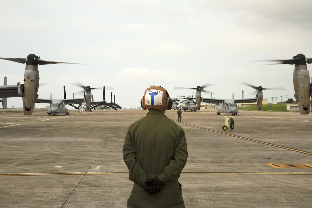 A Marine prepares to guide MV-22 Osprey aircraft before takeoff at Marine Corps Air Station Futenma, Japan, April 17, 2016. The aircraft will be used to support relief efforts following a devastating earthquake near Kumamoto, Japan. The crews and aircraft are assigned to the Marine Medium Tilitrotor Squadron 265, attached to the 31st Marine Expeditionary Unit. Marine Corps photo by Cpl. Jessica Collins