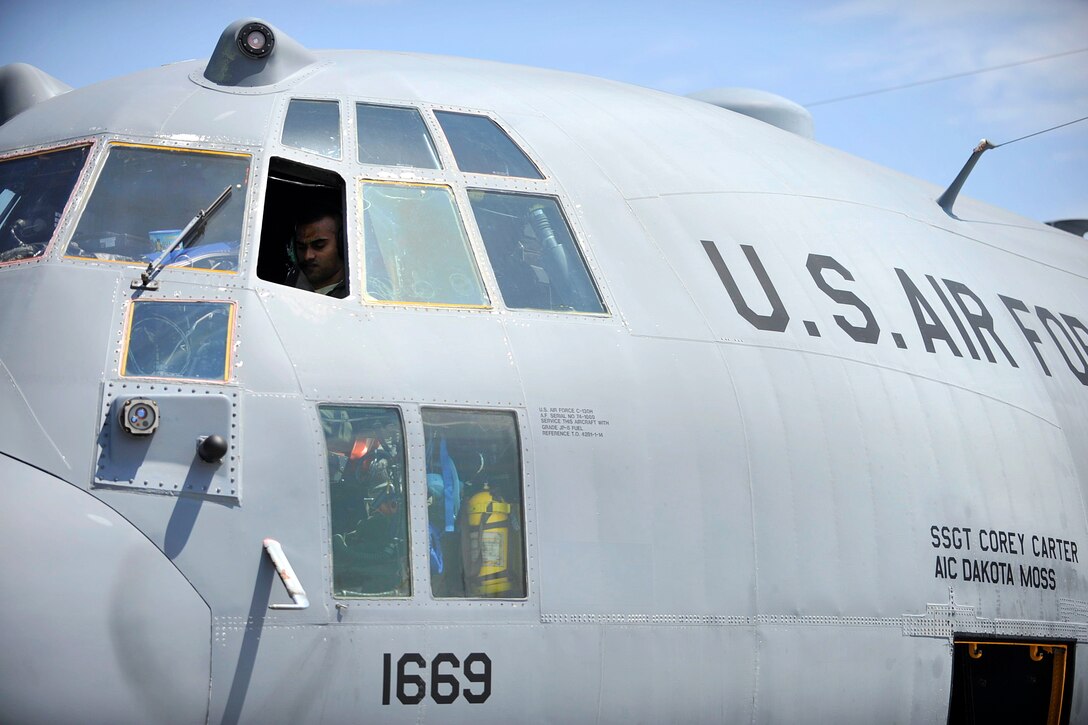 Air Force Capt. Darshan Subramanian performs preflight checks inside the cockpit of a C-130 Hercules aircraft before takeoff at Yokota Air Base, Japan, April 18, 2016, to support relief efforts following a devastating earthquake near Kumamoto, Japan. Subramanian is a pilot assigned to the 36th Air Mobility Squadron. Navy photo by Petty Officer 3rd Class Markus Castaneda