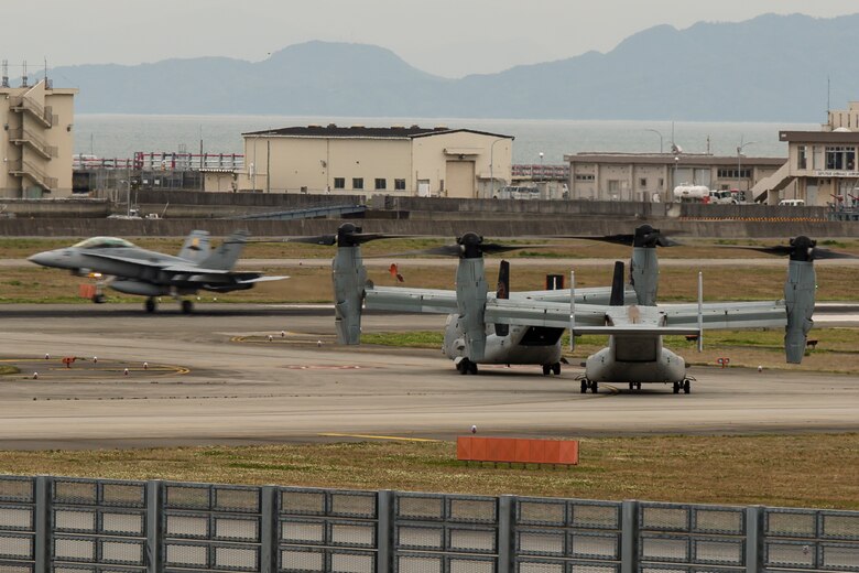 Two MV-22B Ospreys from Marine Medium Tiltrotor Squadron (VMM) 265 (Reinforced)  attached to the 31st Marine Expeditionary Unit wait to take off as an F/A-18 Hornet lands at Marine Corps Air Station Iwakuni, Japan, in support of the Government of Japan’s relief efforts following the devastating earthquake near Kumamoto April 18, 2016. The long-standing relationship between Japan and the U.S. allows U.S. military forces in Japan to provide rapid, integrated support to the Japan Self-Defense Forces and civil relief efforts. (U.S. Marine Corps photo by Lance Cpl. Aaron Henson/Released)