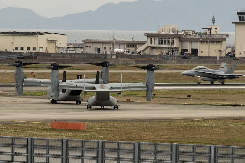 Two MV-22B Ospreys from Marine Medium Tiltrotor Squadron (VMM) 265 (Reinforced)  attached to the 31st Marine Expeditionary Unit wait to take off as an F/A-18 Hornet lands at Marine Corps Air Station Iwakuni, Japan, in support of the Government of Japan’s relief efforts following the devastating earthquake near Kumamoto April 18, 2016. The long-standing relationship between Japan and the U.S. allows U.S. military forces in Japan to provide rapid, integrated support to the Japan Self-Defense Forces and civil relief efforts. (U.S. Marine Corps photo by Lance Cpl. Aaron Henson/Released)