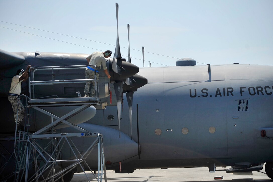 Airmen perform maintenance checks on a C-130 Hercules aircraft before takeoff at Yokota Air Base, Japan, April 18, 2016, to support  relief efforts following a devastating earthquake near Kumamoto, Japan. The airmen are assigned to the 374th Aircraft Maintenance Squadron. Navy photo by Petty Officer 3rd Class Markus Castaneda