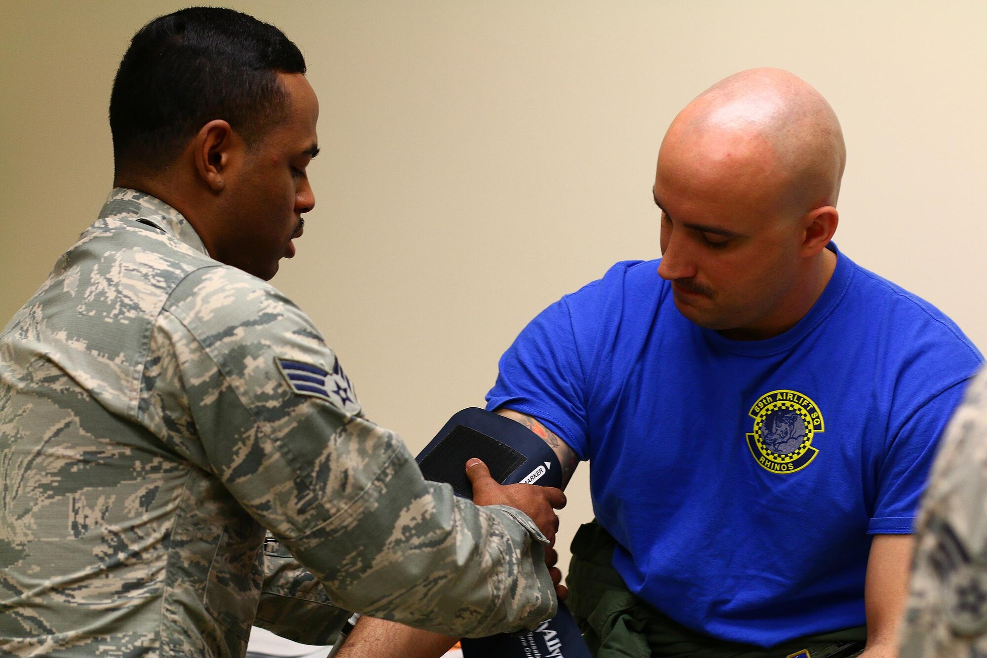 Senior Airman Dalexander Massie, 445th Aerospace Medicine Squadron medical technician, checks the vitals of Capt. Nate Kirstein, 89th Airlift Squadron C-17 Globemaster III pilot, as part of his annual physical health assessment March 5, 2016.