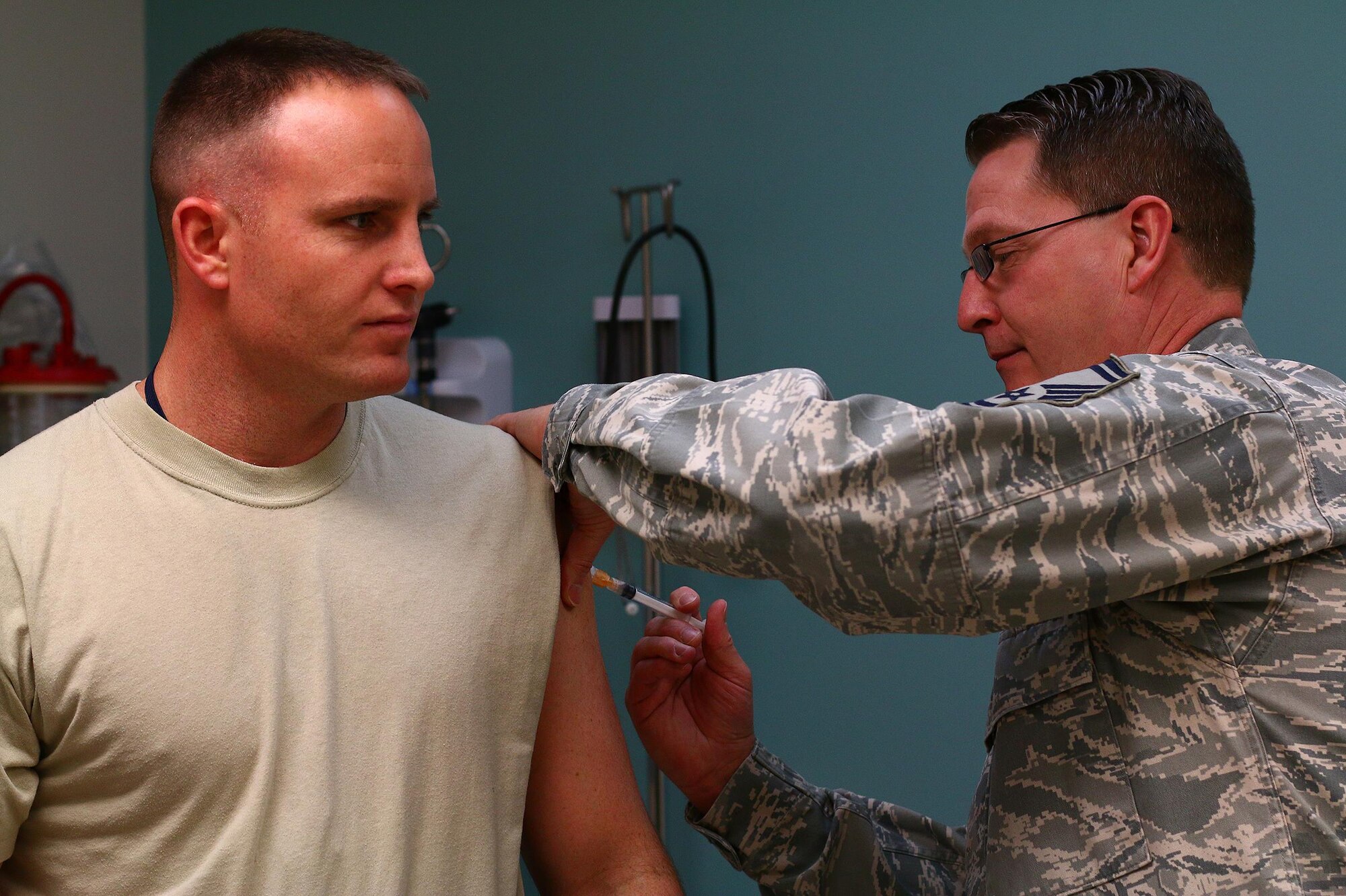 Senior Master Sgt. Todd Noe, 445th Aerospace Medicine Squadron NCO in charge of immunizations, gives Tech. Sgt. Matt Pfeifer, 89th Airlift Squadron loadmaster, an immunization shot as part of his annual physical march 5, 2016.