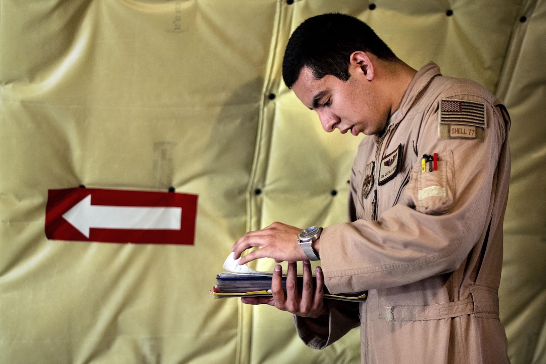 Air Force Senior Airman Castulo checks the manual while he inspects a KC-135 Stratotanker at Al Udeid Air Base, Qatar, April 6, 2016, in support of Operation Inherent Resolve. Castulo is an aerial refueling specialist assigned to the 340th Expeditionary Air Refueling Squadron. Air Force photo by Tech. Sgt. Nathan Lipscomb 