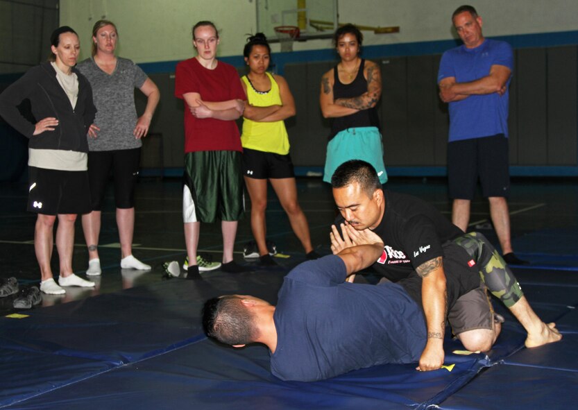 Staff Sgts. Pablo Rios and Adrian Lizama, 379th Expeditionary Logistics Readiness Squadron, demonstrate an escape move during a basic self defense class at the Blatchford-Preston Complex gym April, 6 at Al Udeid Air Base, Qatar. The self-defense classes are part of a series of events planned to raise awareness during national Sexual Assault Awareness and Prevention Month, which is observed throughout April. (Photo by Sgt. 1st Class Patricia Deal)