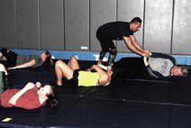 Staff Sgt. Pablo Rios, 379th Expeditionary Logistics Readiness Squadron, helps Italian Army Col. Roberto Rossi with an escape move during a basic self defense class at the Blatchford-Preston Complex gym April 6 at Al Udeid Air Base, Qatar. The self-defense classes are part of events planned to raise awareness during national Sexual Assault Awareness and Prevention Month which is observed throughout April. (Photo by Sgt. 1st Class Patricia Deal)