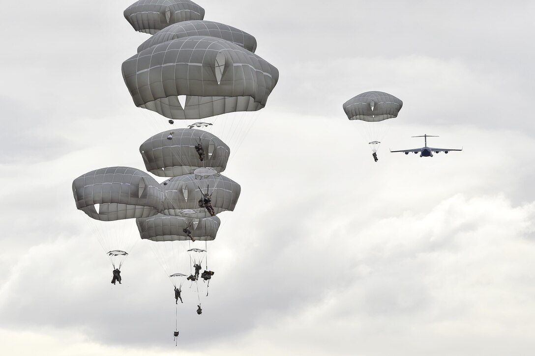 Paratroopers descend after jumping from an Air Force C-17 Globemaster III during a practice forced-entry parachute assault on Malemute drop zone at Joint Base Elmendorf-Richardson, Alaska, April 5, 2016. Air Force photo by Alex Pena