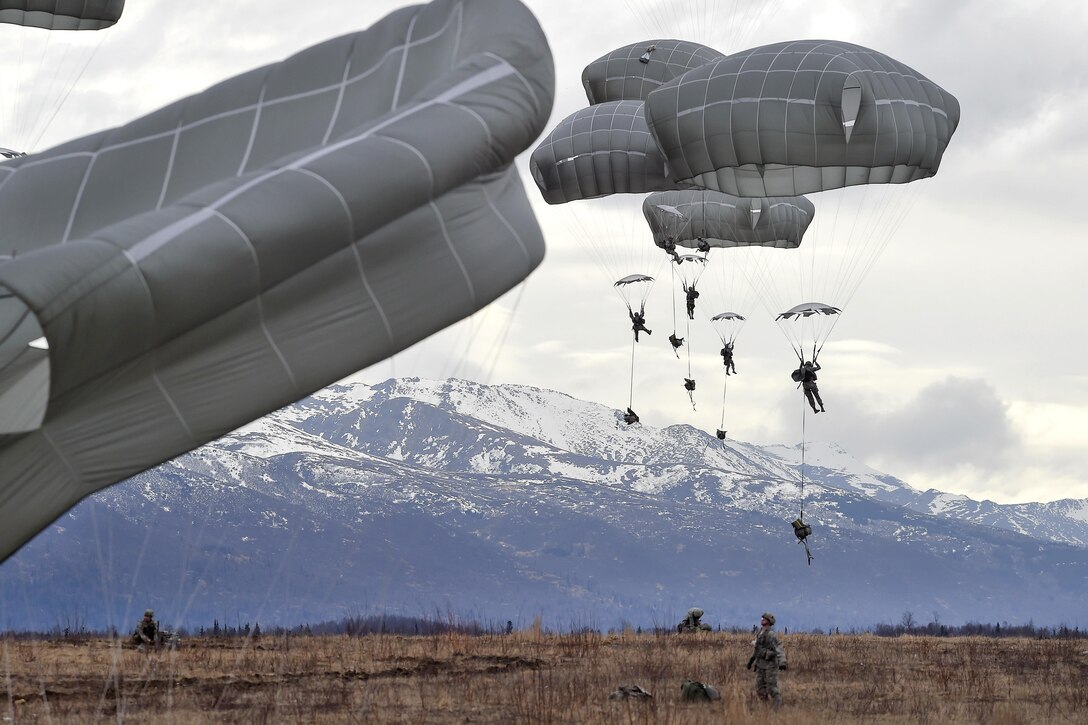 Paratroopers descend with full chutes during a practice forced-entry parachute assault on Malemute drop zone at Joint Base Elmendorf-Richardson, Alaska, April 5, 2016. Air Force photo by Alex Pena