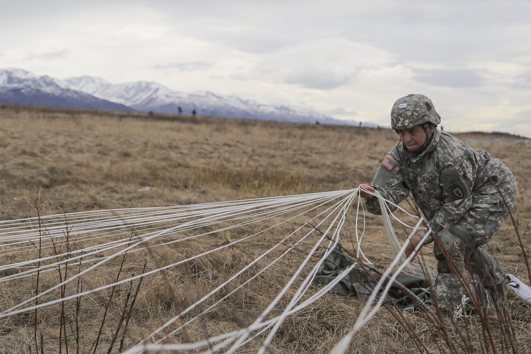 Army Sgt. Melissa Perez recovers a parachute during a practice forced-entry parachute assault on Malemute drop zone at Joint Base Elmendorf-Richardson, Alaska, April 5, 2016. Perez is a paratrooper assigned to the 25th Infantry Division’s 3rd Battalion, 509th Infantry Regiment, 4th Infantry Brigade Combat Team (Airborne), Alaska. Air Force photo by Alex Pena