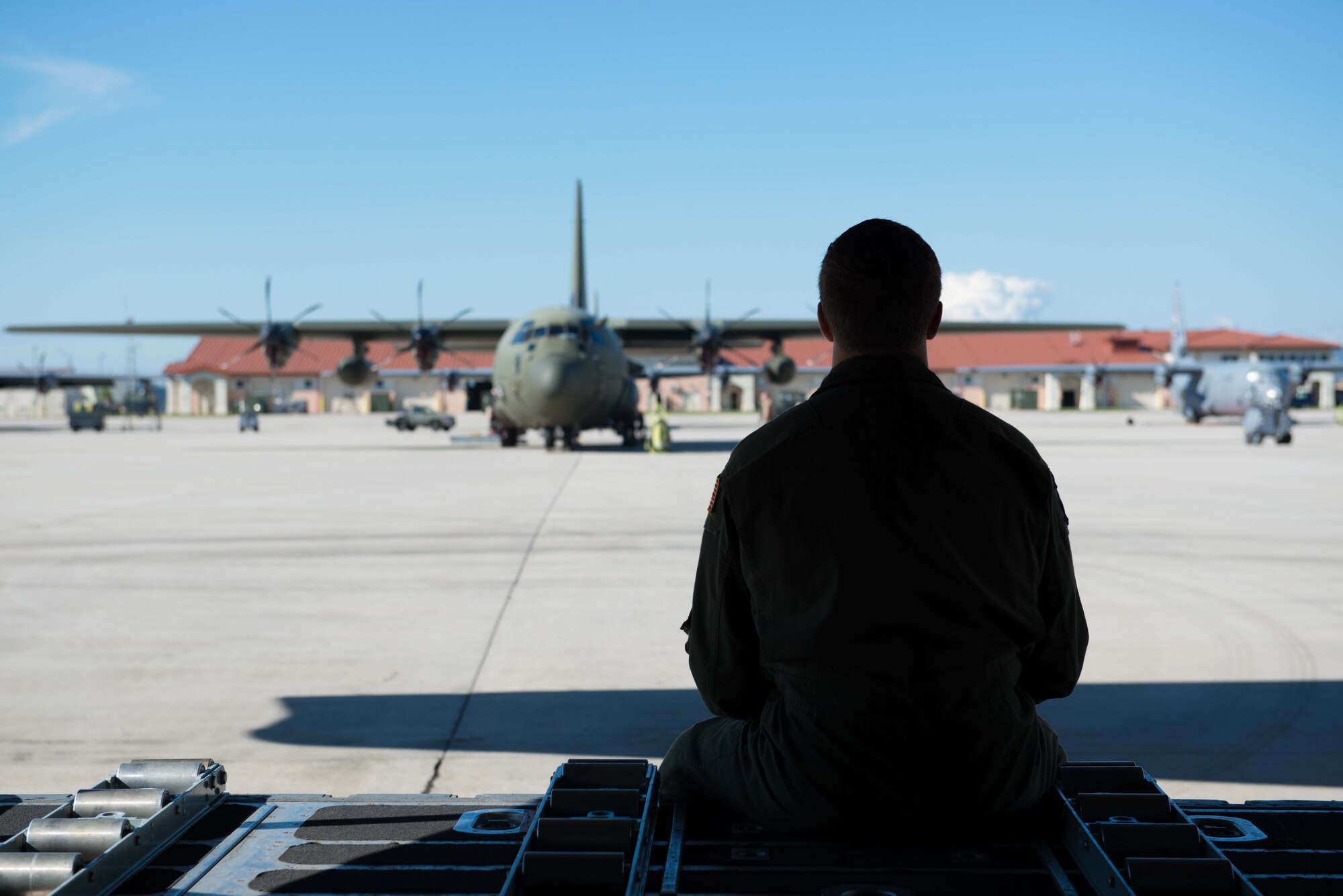 Senior Airman Alec Miller, a loadmaster from the 96th Airlift Squadron, sits on the ramp of a C-130 at Aviano AB, Italy, on April 10. (U.S. Air Force photo by Staff Sgt. Trevor Saylor)