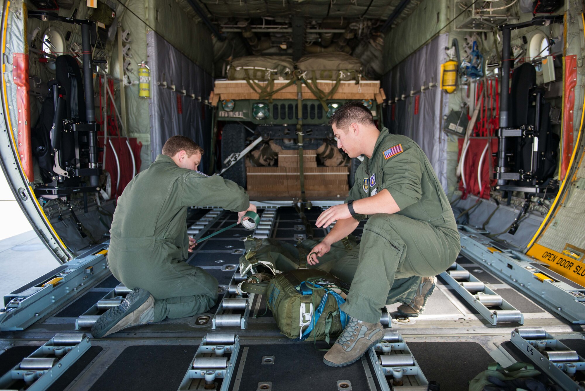 Senior Airman Alec MIller, left, and Master Sgt. Dave Montanez, both loadmasters from the 96th Airlift Squadron, prepare a parachute for a cargo load to be dropped in support of Exercise Saber Junction at Aviano AB, Italy, on April 10. (U.S. Air Force photo by Staff Sgt. Trevor Saylor)