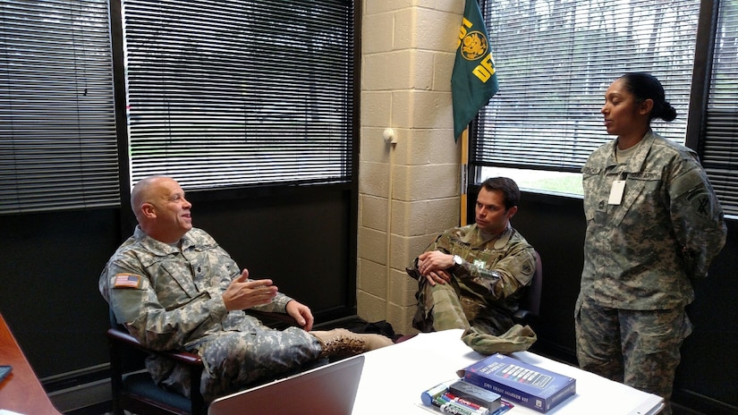 301st IO Battalion Commander Lt. Col. Patrick Sheridan discusses the validation exercise with Operations Officer Maj. Jason Romanello and Advisor Master Sgt. Jigna Chokshi at the Dekalb U.S. Army Reserve Center at Fort George G. Meade, Md., March 21, 2016. Members of the 301st IO Battalion conducted a validation exercise to earn certification on core information operations competencies. (U.S. Army photo by Capt. Jean Oliver/Released)