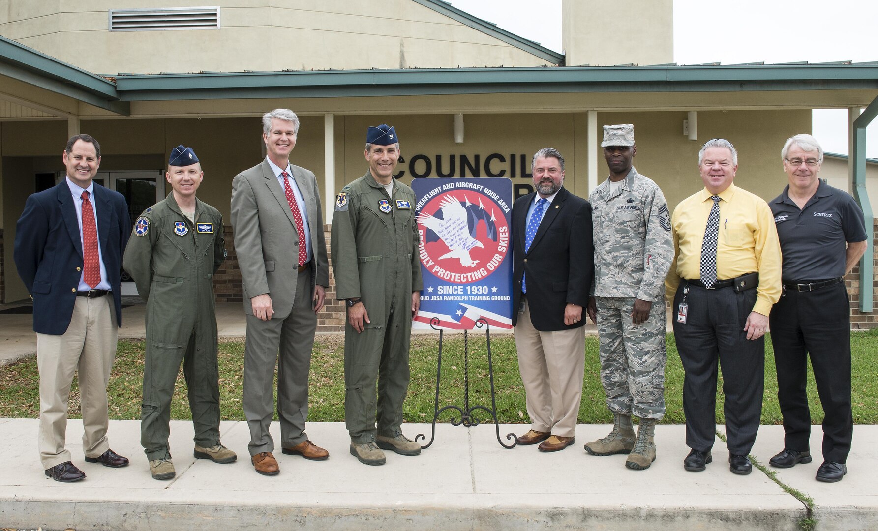 From left to right: Brian James, Schertz executive director of development, Lt. Col. Emil Bliss, 12th Flying Training Wing community initiatives director, John Kessel, Schertz city manager, Col. Matthew Isler, 12th FTW commander, Michael Carpenter, mayor of Schertz, Chief Master Sgt. Troy Palmer, 12th FTW command chief, Dudley Wait, executive director of operations, and Robin Thompson, Schertz place 5 council member, unveil the new city sign in front of the Schertz Council Chambers April 12, 2016. Joint Base San Antonio-Randolph and the city of Schertz are committed to keeping residents informed about aircraft training in the local area and the effects it may have on noise levels.