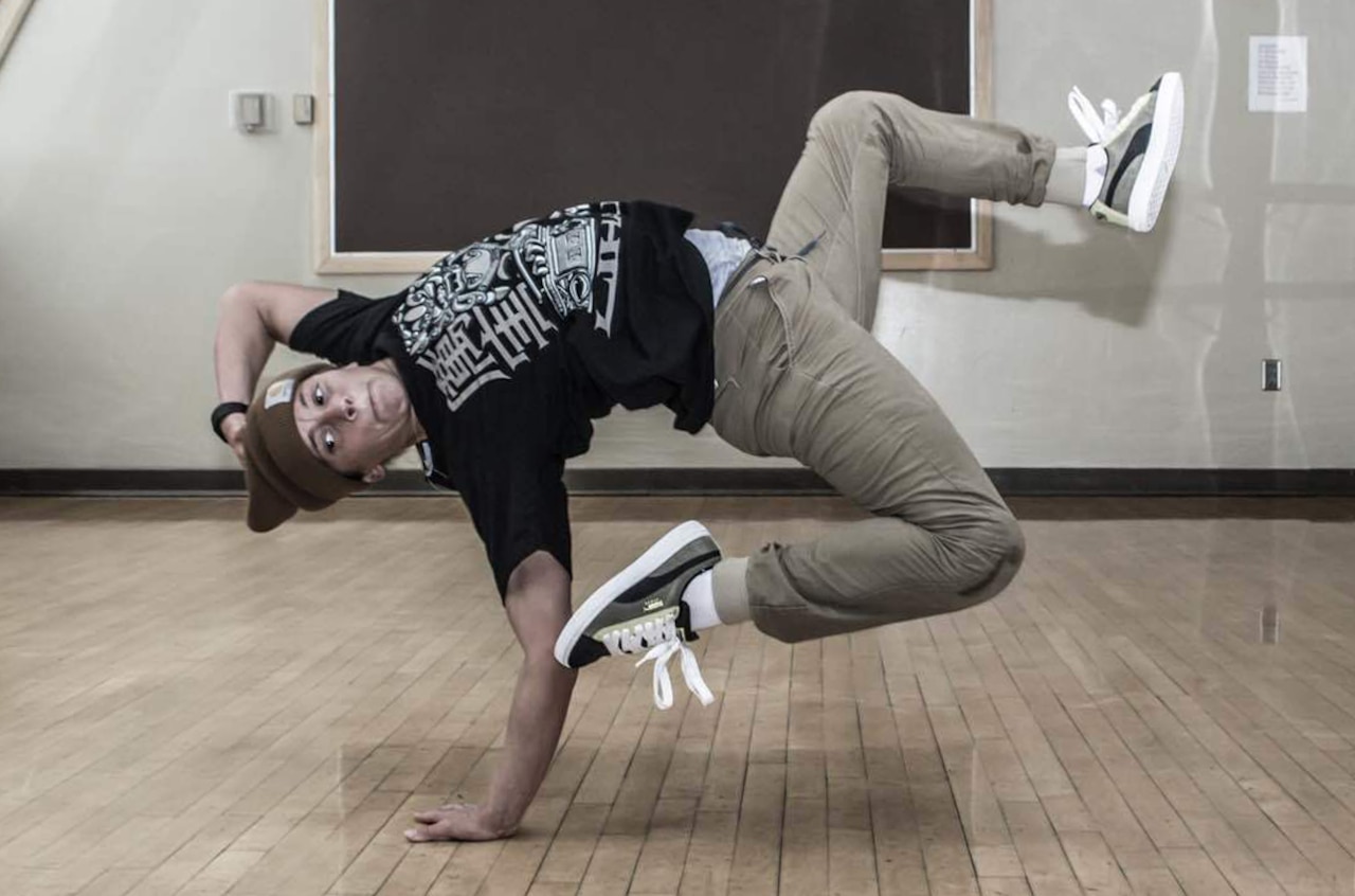 Alaska Army National Guardsman Sgt. Brianna McMillen, a UH-60 Black Hawk helicopter crew chief with 1st Battalion, 207th Aviation Regiment, break dances at the Fairview Recreation Center in Anchorage, Alaska, July 23, 2015. Courtesy photo by Darel Carey, LiHai Art