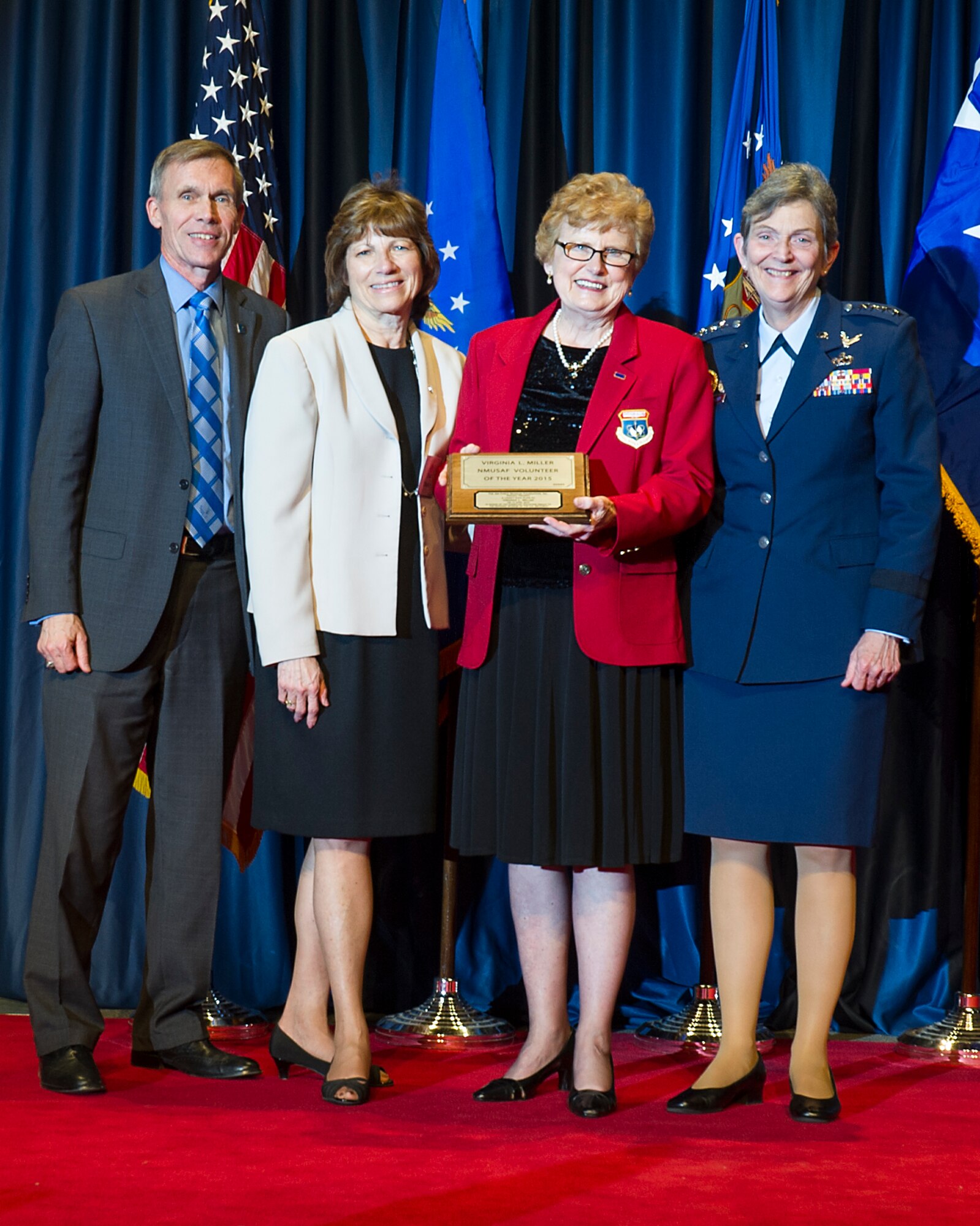 DAYTON, Ohio -- Virginia Miller (red jacket) received the 2015 Director’s Award for Volunteer of the Year for her dedication and excellence in serving the National Museum of the U.S. Air Force. (from left to right) Museum Director Lt. Gen. (Ret.) Jack Hudson, Air Force Museum Foundation Chairman Board of Managers Fran Duntz, Museum Volunteer Virginia Miller, and Commander of Air Force Materiel Command, Gen. Ellen M. Pawlikowski. (U.S. Air Force photo)  