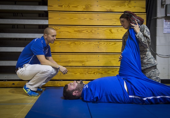 Maj. (Dr.) Sean Martin, the chief of sports medicine with Air Force Special Operations Command Office of the Surgeon General, watches as Staff Sgt. Jennifer Enderud, the NCO in charge of physical therapy with the 1st Special Operations Medical Operations Squadron, stretches an  athlete’s hamstring during a Warrior Games training camp at Hurlburt Field, Fla., April 4, 2016. Martin and other medical technicians provide extra services to the athletes during the training camp to ensure as much of their time as possible is spent in the competition and not on the sideline. (U.S. Air Force photo by Staff Sgt. Marleah Miller)
