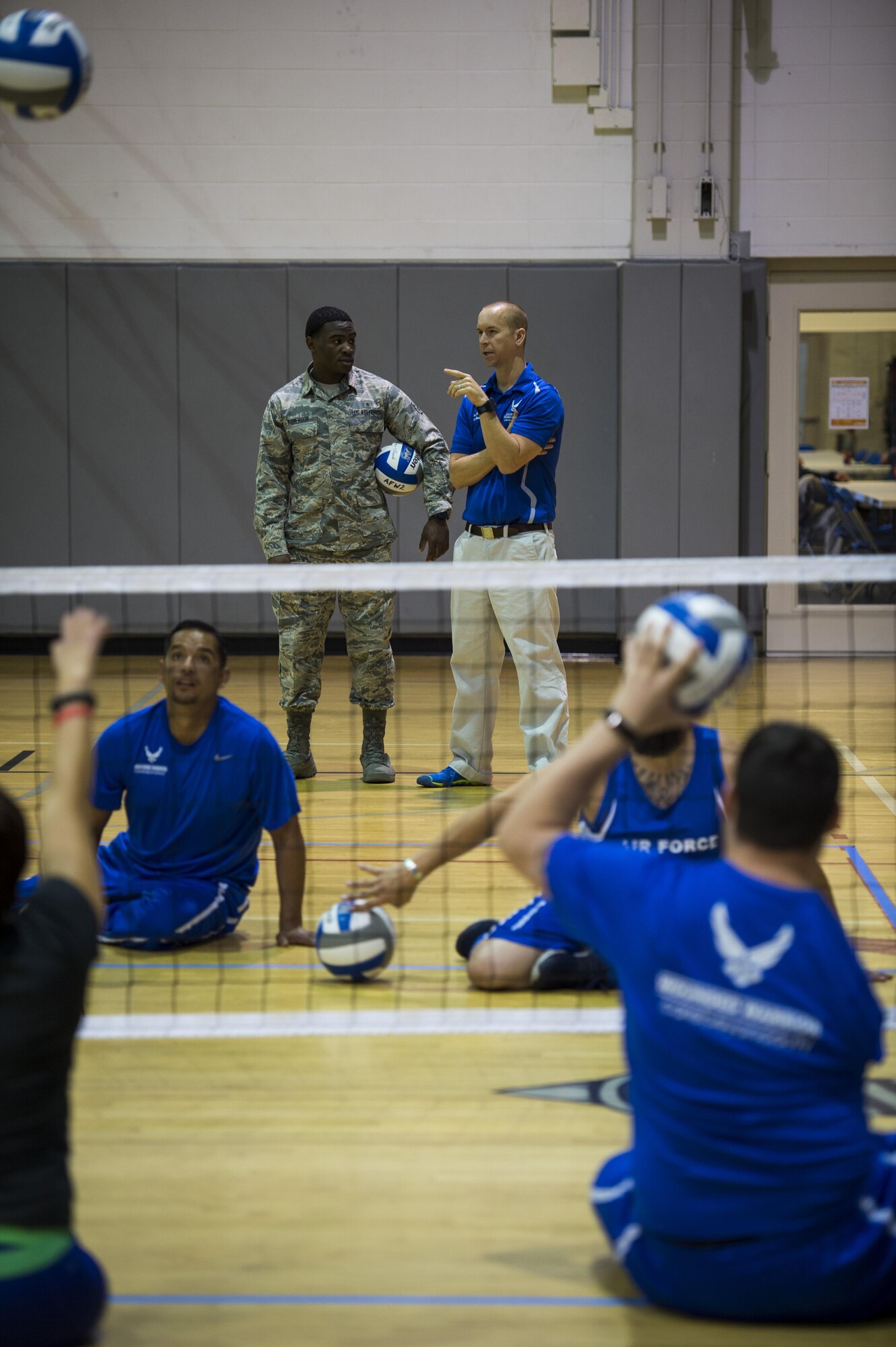 Maj. (Dr.) Sean Martin, right, the chief of sports medicine with Air Force Special Operations Command Office of the Surgeon General, talks to Airman 1st Class Astin Roberson, left, a physical therapy technician with the 1st Special Operations Medical Operations Squadron, at sitting volleyball practice during a Warrior Games training camp at Hurlburt Field, Fla., April 4, 2016. Martin and other medical technicians provide extra services to the athletes during the training camp to ensure as much of their time as possible is spent in the competition and not on the sideline. (U.S. Air Force photo by Staff Sgt. Marleah Miller)