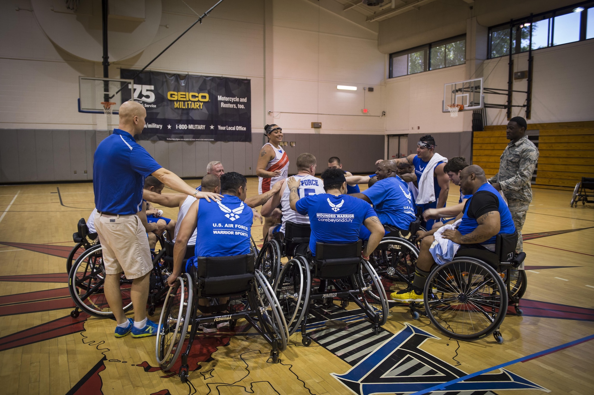 Maj. (Dr.) Sean Martin the chief of sports medicine with Air Force Special Operations Command Office of the Surgeon General, joins in the huddle with wounded-warrior athletes after wheelchair basketball practice at Hurlburt Field, Fla., April 5, 2016. The Warrior Games consist of seven sports including archery, cycling, shooting, sitting-volleyball, swimming, track and field, and wheelchair basketball. (U.S. Air Force photo by Staff Sgt. Marleah Miller)