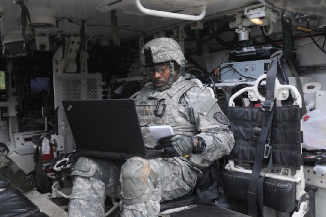 A soldier assigned to the 780th Military Intelligence Brigade prepares his equipment inside a Stryker vehicle during an integrated cyber exercise at Joint Base Lewis-McChord, Wash., Oct. 21, 2015. Army photo