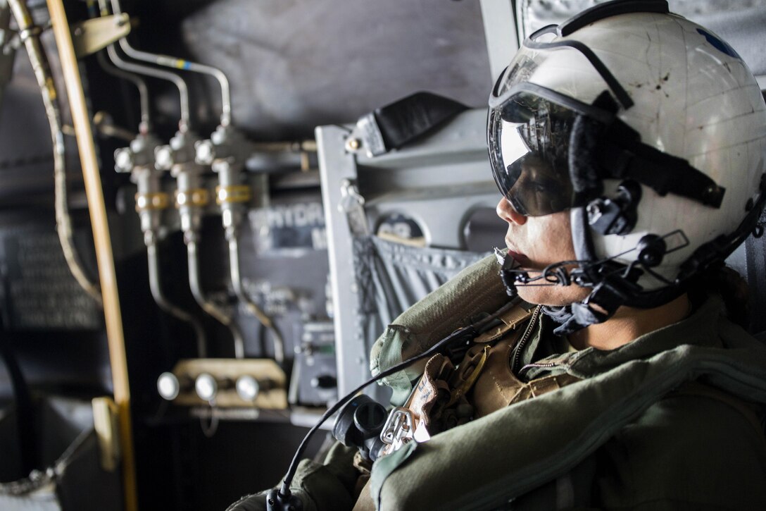 A Marine Corps crew chief checks for safety clearance during takeoff from Marine Corps Air Station Iwakuni, Japan, April 18, 2016. Marine Corps photo by Cpl. Nathan Wicks