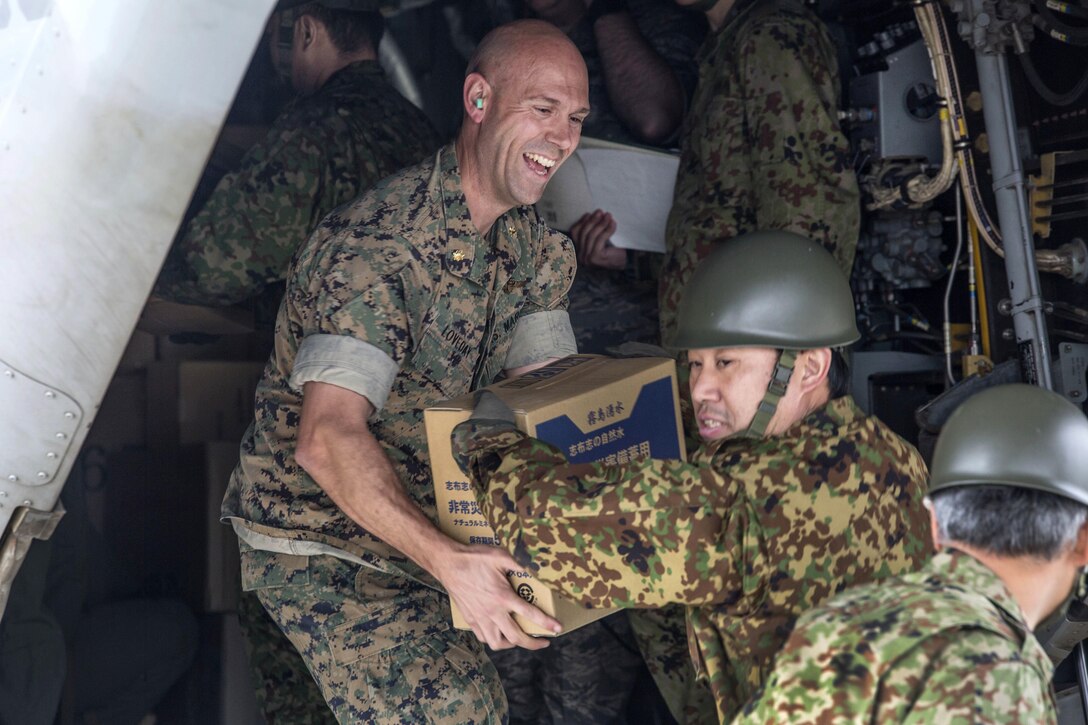 U.S. Marine Corps Maj. Loveday, left, and Japanese soldiers load boxes of humanitarian aid into an MV-22 Osprey aircraft at Japanese Camp Takayubaru, Japan, April 18, 2016. Marine Corps photo by Cpl. Nathan Wicks