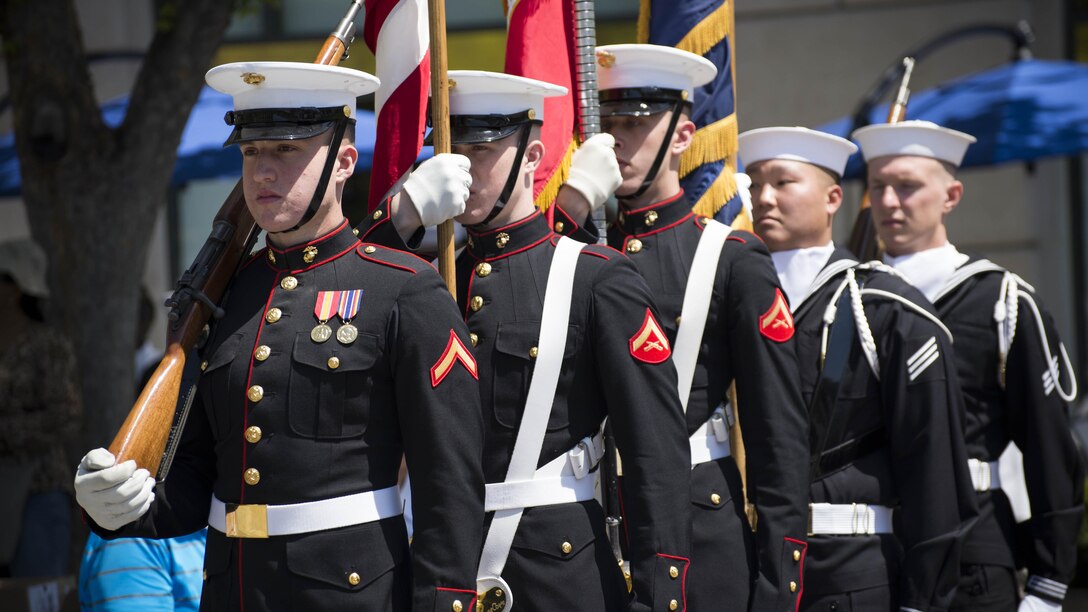 Marines from Marine Barracks Washington and sailors from the U.S. Navy Ceremonial Guard stand by to parade the colors during the 25th annual Blessing of the Fleets ceremony at U.S. Navy Memorial in Washington, April 16. The Blessing of the Fleets ritual is intended to safeguard crews and ships from the danger of the seas through a blessing given by a clergyman at the water’s edge. During the ceremony, sailors from the U.S. Navy’s Ceremonial Guard and Marines from the U.S. Marine Barracks, Washington, DC, proceeded across the outdoor plaza’s “Granite Sea” and poured water from the Seven Seas and Great Lakes into the surrounding fountains, “charging” them to life and welcoming the spring season.