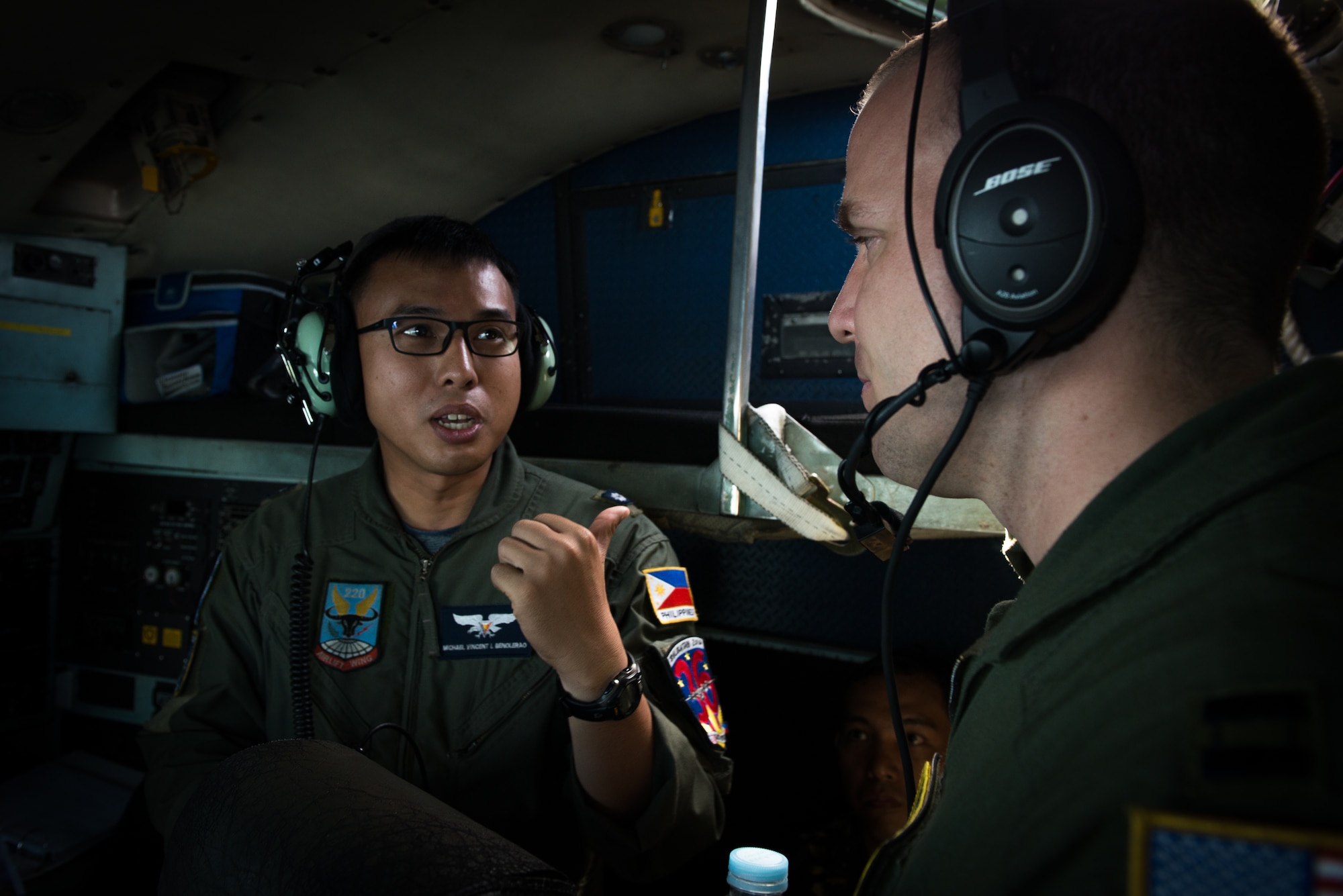 Philippine Air Force Maj. Michael Vincent L. Benvolerao, 220th Airlift Wing C-130 Hercules pilot, discusses flight operations with U.S. Air Force Capt. David Lynn, 36th Airlift Squadron C-130 navigator, during a flight off the coast of Mactan, Philippines, as a part of Exericse Balikatan April 14, 2016. This year marks the 32nd iteration of Balikatan, an annual Philippine- U.S. alliance focused on a variety of missions, including humanitarian assistance, maritime law enforcement, and environmental protection.(U.S. Air Force photo by Staff Sgt. Michael Smith/ Released)