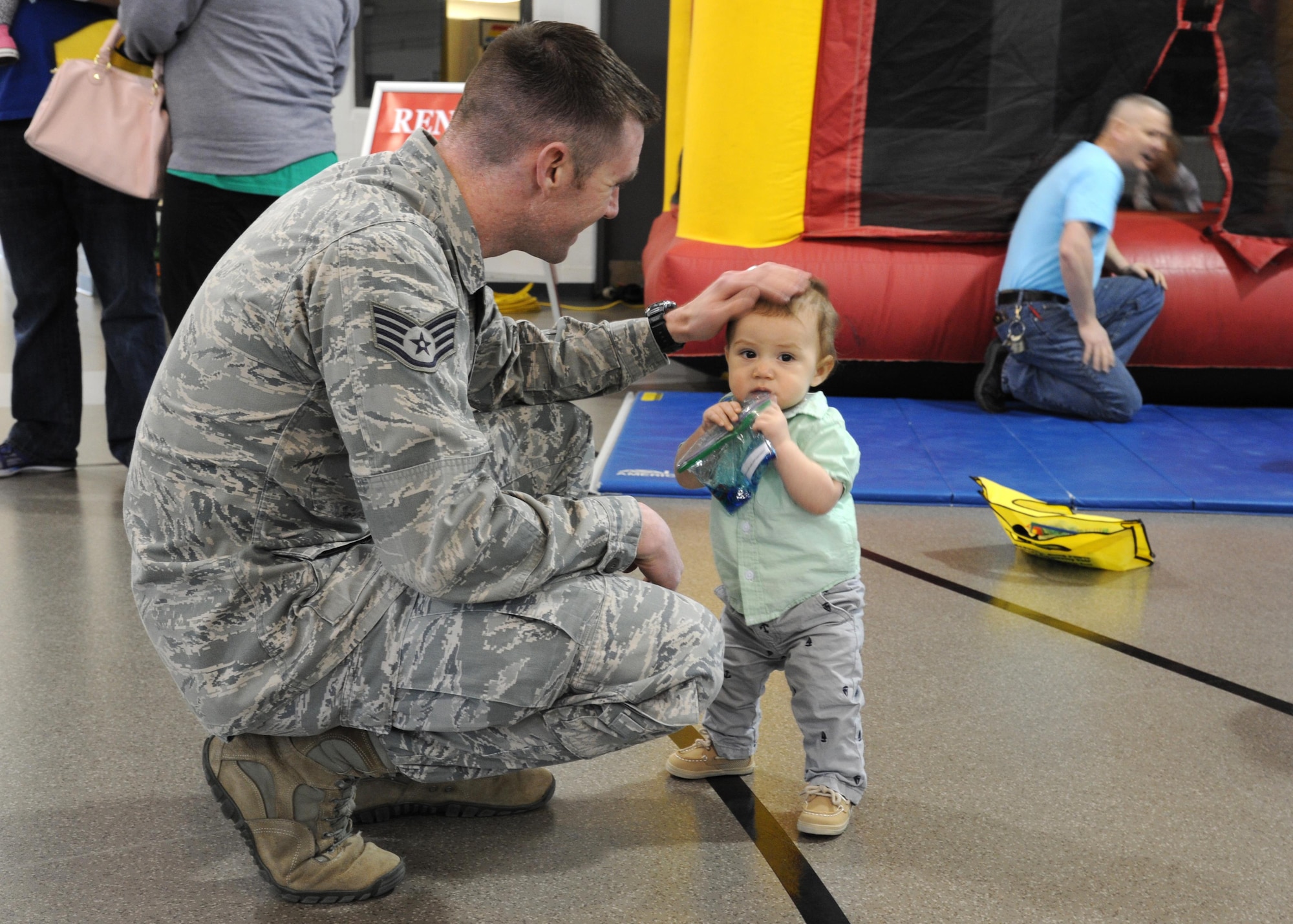 Staff Sgt. Christopher Ford, 319th Operations Support Squadron NCO-in-charge of weather flight, pats his son CJ, 10-months-old, on the head April 5, 2016, on Grand Forks Air Force Base, N.D. Ford and his son participated in the Beautiful Child Photo Shoot and Activity Fair, an event on Grand Forks AFB, as part of the Month of the Military Child celebration. (U.S. Air Force photo by Airman 1st Class Ryan Spark/Released)