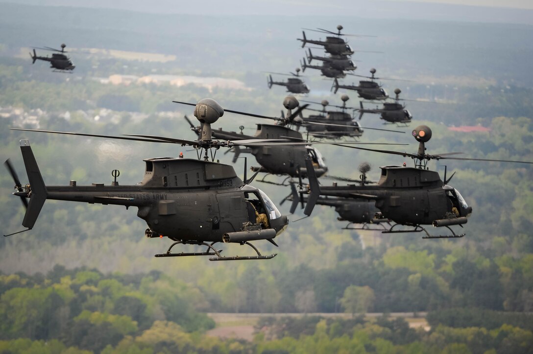 Thirty-two OH-58D Kiowa Warriors conduct a flyover above Fort Bragg, N.C., 2016, during the final stateside flight of the aircraft, April 15, 2016. The OH-58D Kiowa Warrior has been a mainstay in the skies over the area for more than 25 years. DoD photo by Kenneth Kassens
