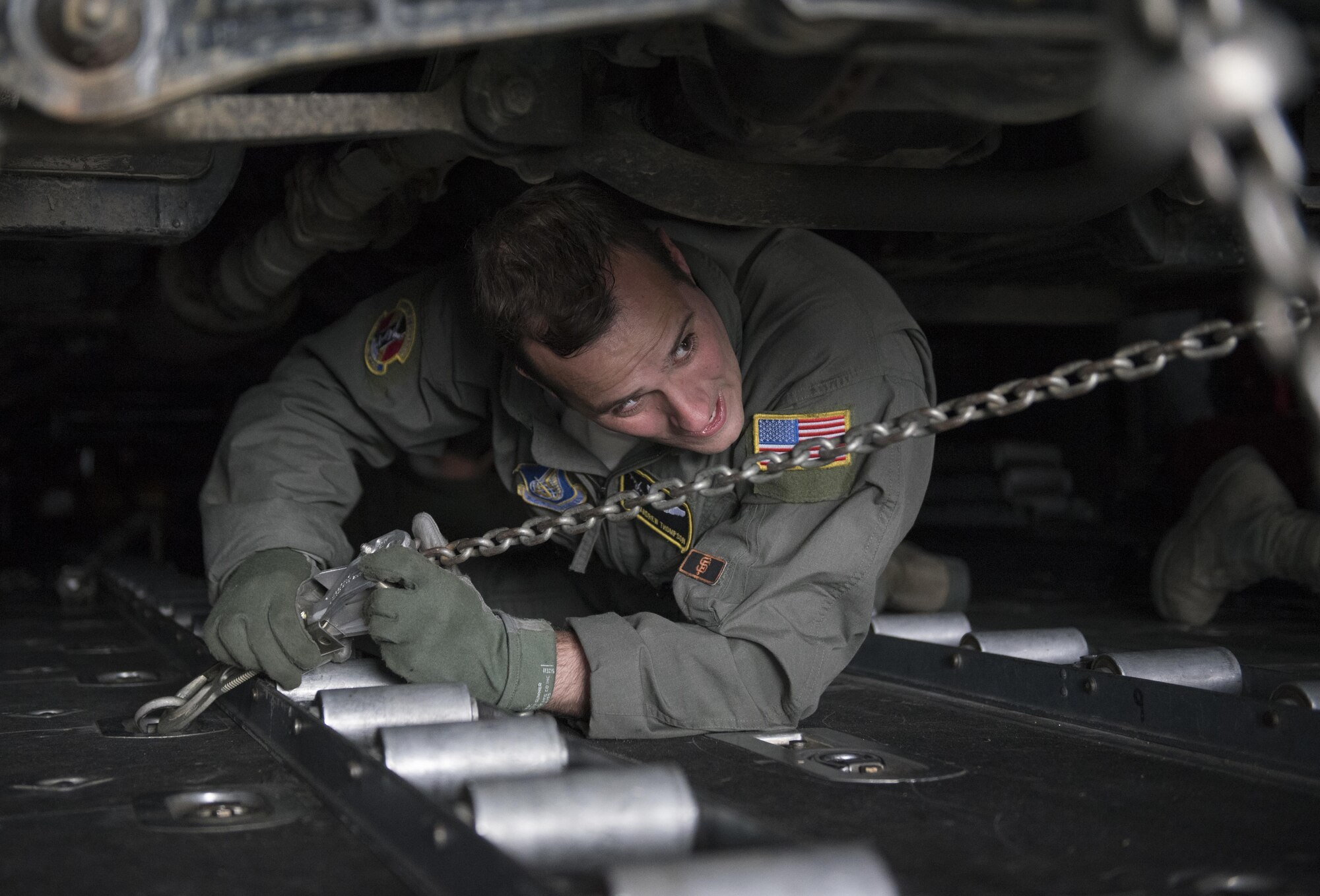 U.S. Air Force Staff Sgt. Andrew Thompson, 36th Airlift Squadron loadmaster, uses a chain to strap down a Japan Ground Self-Defense Force vehicle to a C-130 Hercules at Chitose, Hokkaido, Japan, April 18, 2016. The 374th Airlift Wing assisted the Government of Japan by airlifting vehicles and personnel from Hokkaido to the island of Kyushu in response of the recent earthquakes. (U.S. Air Force photo by Staff Sgt. Michael Washburn/Released)
