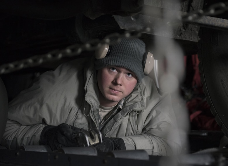 U.S. Air Force Senior Airman Brandon Ihnat, 374th Logistics Readiness Squadron air transportation specialist, checks two chains that secure a Japan Ground Self-Defense Force vehicle to a C-130 Hercules at Chitose, Hokkaido, Japan, April 18, 2016. The vehicles were being transported from Hokkaido to the island of Kyushu to assist in disaster relief efforts. (U.S. Air Force photo by Staff Sgt. Michael Washburn/Released)
