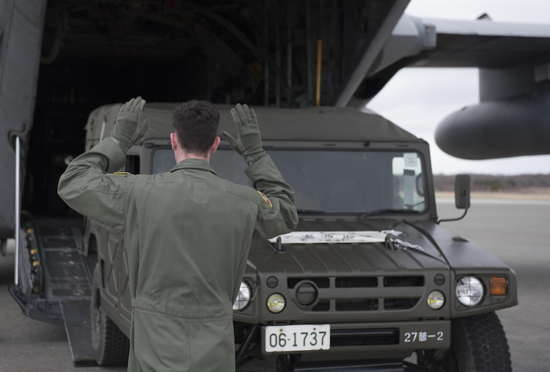 U.S. Air Force Senior Airman Dustin Brown, 36th Airlift Squadron loadmaster, marshals a Japan Ground Self-Defense Force vehicle into a C-130 Hercules at Chitose, Hokkaido, Japan, April 18, 2016. Two C-130s from Yokota Air Base, Japan picked up four vehicles and eight JGSDF members, airlifting them to Kumamoto Prefecture to assist in disaster relief following a series of earthquakes that struck Japan. (U.S. Air Force photo by Staff Sgt. Michael Washburn/Released)
