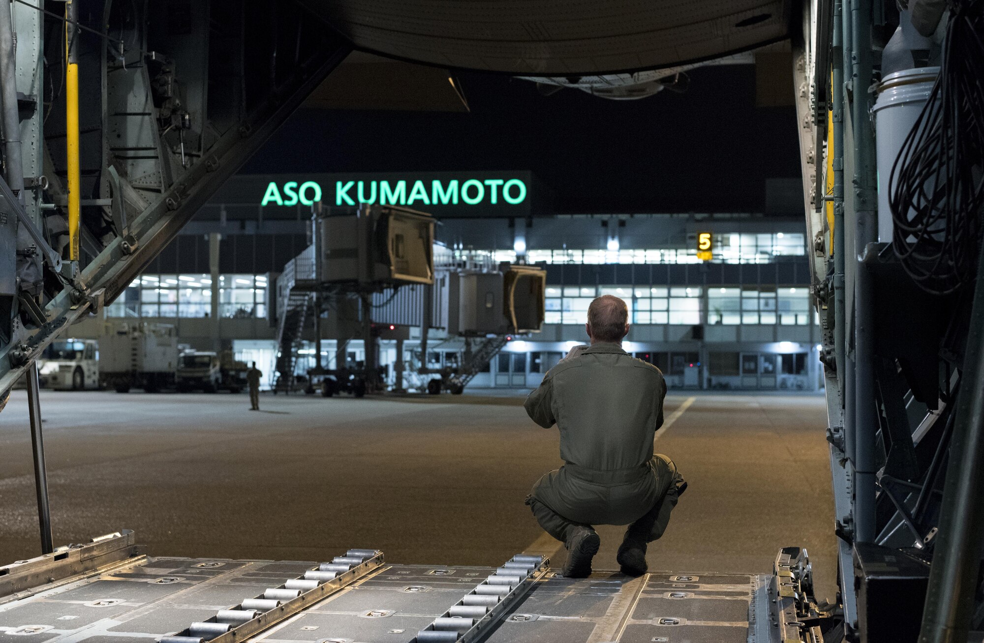 U.S. Air Force Master Sgt. Ryan Atkinson, 36th Airlift Squadron loadmaster, looks out the back of a C-130 Hercules after dropping off two Japan Ground Self-Defense Force vehicles and four JGSDF members at Kumamoto Prefecture, Japan, April 18, 2016. The island of Kyushu was hit by a devastating earthquake April 16, 2016, and U.S. Forces Japan assisted the Government of Japan relief efforts by airlifting supplies, equipment and personnel to the affected areas. (U.S. Air Force photo by Staff Sgt. Michael Washburn/Released)