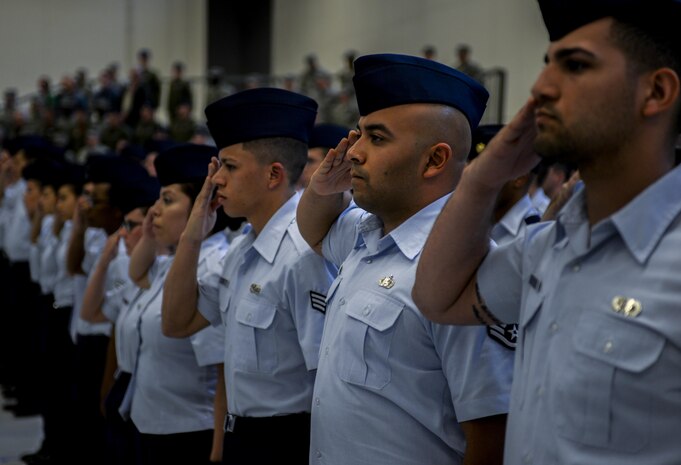 Airmen from the 57th group salute as the national anthem is played at the 57th Change of Command at Nellis Air Force Base, Nev., April 16, 2016. The 57th WG oversees the dynamic and challenging flying operations at Nellis Air Force Base and conducts advanced aircrew, cyber, cyber-space, logistics, command and control training through the U.S. Air Force Weapons School, Red Flag and Green Flag exercises. (U.S. Air Force photo by Airman 1st Class Kevin Tanenbaum)