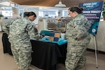 COLUMBUS, Ohio (April 6, 2016) Air Force Master Sgt. Maggie Ladd (right) discusses the symbolism of fabric squares to Army Capt. Miracle Garcia at an information fair for Sexual Assault Awareness and Prevention Month. The squares are worn to show support for sexual assault survivors during "Denim Day" on April 27.