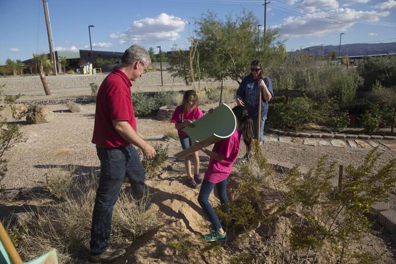 Brian Henen, ecologist, Natural Resources and Environmental Affairs,  helps Leah Garza-Horbal and Lauren Middelton, girl scouts, Troop 1744, replace the tunnel of the new tortoise borrow for ambassador tortoises Thelma and Louise at the Combat Center’s Archeology and Paleontology Curation Center April 12, 2016. The troop visited the installation to earn their Wildlife Habitat Badges which are earned through education on native wild animals and how they live. (Official Marine Corps photo by Cpl. Thomas Mudd/Released)