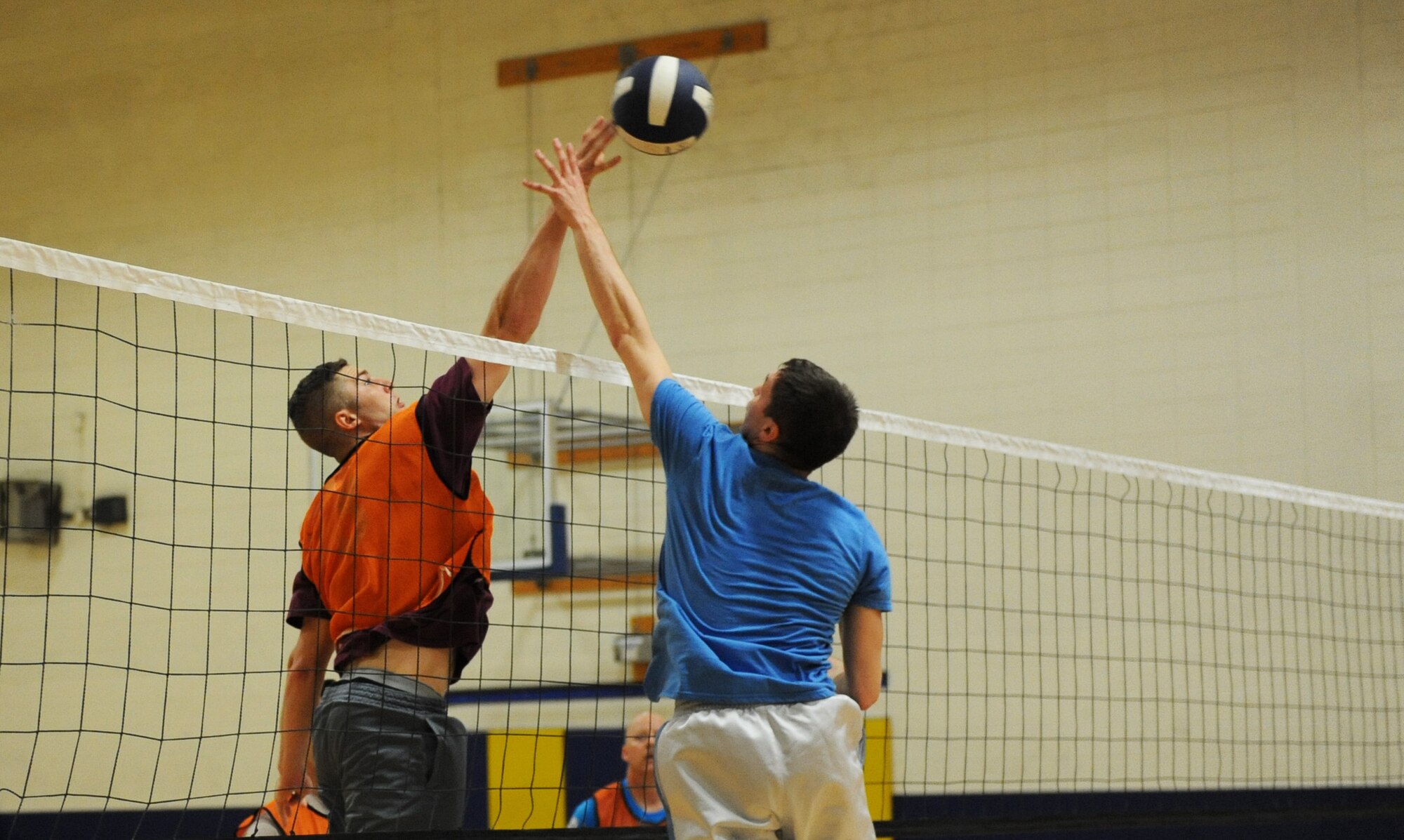First Lt. Matthew Weiser, 81st Training Support Squadron international military student office officer in charge, tips the ball over Senior Airman Montana Diehl, 85th Engineering Installation Squadron airfield systems technician, during the intramural volleyball championship game at the Blake Fitness Center April 14, 2016, Keesler Air Force Base, Miss. The 85th EIS defeated the 81st TRSS, 2-1, to win the intramural volleyball championship. (U.S. Air Force photo by Kemberly Groue)