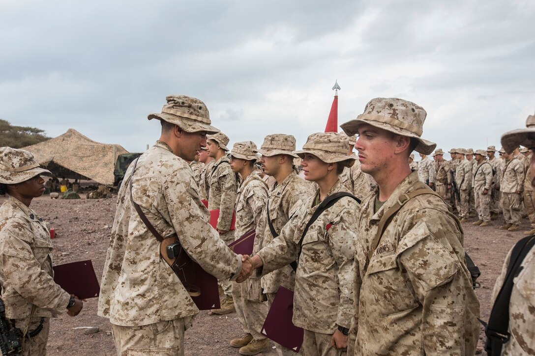 U.S. Marines with Battery B, Battalion Landing Team 2nd Battalion, 1st Marine Regiment, 13th Marine Expeditionary Unit make time to award the Marines who've earned it in Djibouti, Africa, Apr. 11, 2016.(U.S. Marine Corps photo by Cpl. Alvin Pujols/RELEASED)