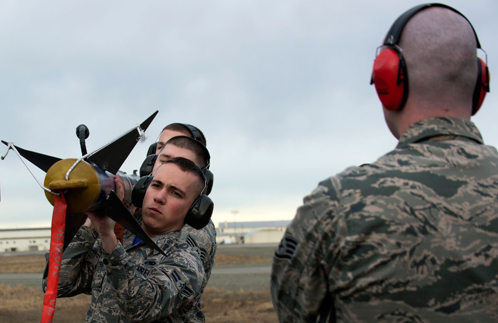 U.S. Air Force Staff Sgt. Jarrett Hayman evaluates Airmen from the 525th Aircraft Maintenance Unit transporting a munition during the first quarter load crew competition at Joint Base Elmendorf-Richardson, Alaska, April 15, 2016. Each member used a three-Airman team to properly load a munition onto an aircraft. (U.S. Air Force photo by Staff Sgt. Sheila deVera)