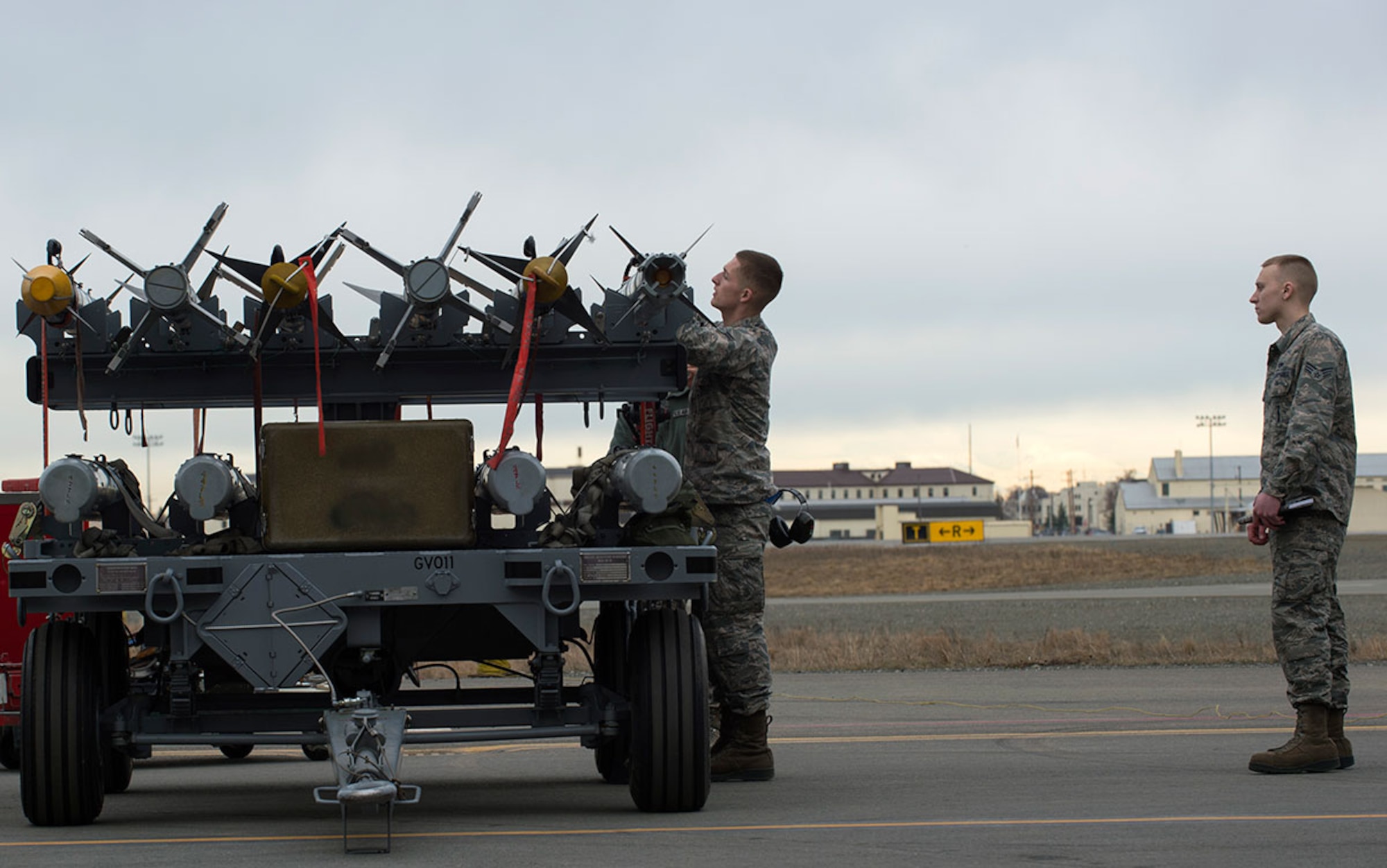 Evaluator Senior Airman Tyler Kaltenborn from the 3rd Maintenance Group, watches Airman 1st Class Jacob Niles conduct a munition preparation during the first quarter load crew competition at Joint Base Elmendorf-Richardson, Alaska, April 15, 2016. Quarterly load crew competitions showcase the combat readiness and effectiveness of load crew teams to safely and properly arm an aircraft with time constraints to meet mission challenges. (U.S. Air Force photo by Staff Sgt. Sheila deVera)