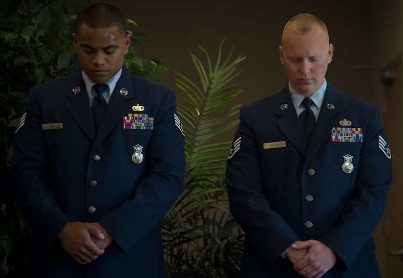 Staff Sgt. Sonny Vaa Jr., 811th Security Forces Squadron vice presidential security team member, and Staff Sgt. Chad Holling, 811th SFS vice presidential security team leader, bow their heads in prayer during the Vice Presidential Service Badge awards ceremony at Joint Base Andrews, Md., April 15, 2016. The VPSB is awarded to military members who serve as a full-time uniformed service aide to the VP of the United States of America. (U.S. Air Force photo by Senior Airman Mariah Haddenham/Released)