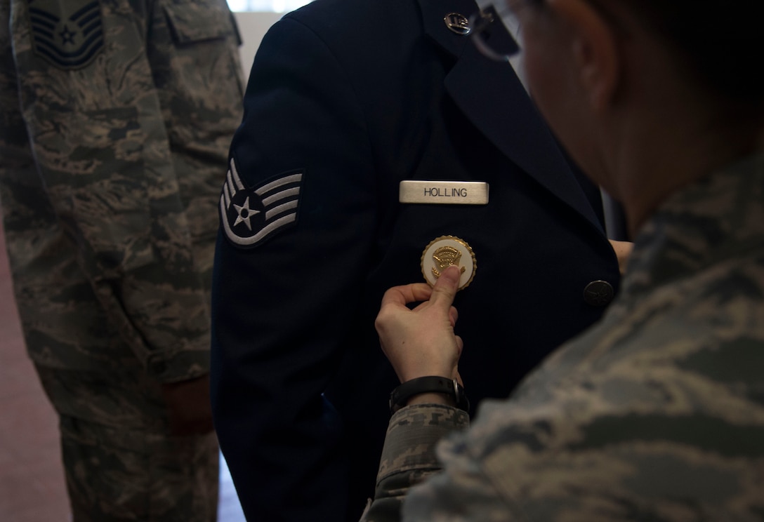 Lt. Col. Sarah Isbill, the 811th Security Forces Squadron commander, pins Staff Sgt. Chad Holling, the 811th SFS vice presidential security team leader, with the Vice Presidential Service Badge at Joint Base Andrews, Md., April 15, 2016. Less than 500 VPSB’s have been issued since its establishment in 1970. (U.S. Air Force photo by Senior Airman Mariah Haddenham/Released)